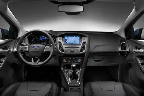 Interiör i en Ford Focus MK2 med ratt, instrumentpanel och mittkonsol. Navigationssystemet visar en karta.