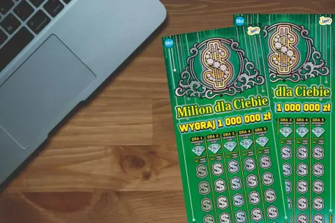 Prawdziwa historia polaka który wygrał milion złotych w zdrapce za 5 zł. Dwie zielone zdrapki Lotto "Milion dla Ciebie" leżą obok laptopa.