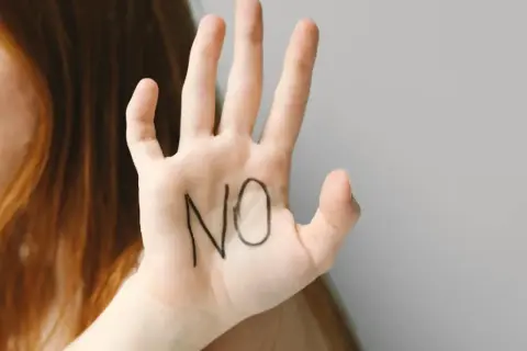 Dłoń z napisem "NO" symbolizuje asertywność i pokazuje, jak nie dać sobie wejść na głowę.