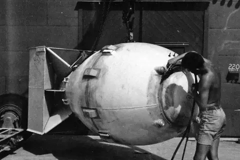 En man arbetar på en stor bomb, kanske för ett film om atombomben. Den hänger i en kran.
