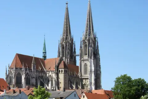 Der Regensburger Dom mit seinen markanten Türmen ragt majestätisch in den blauen Himmel.