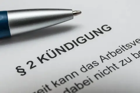 Stift liegt auf Dokument mit "Kündigung". Nach 10 Jahren im Job ist die Abfindung ein wichtiges Thema.
