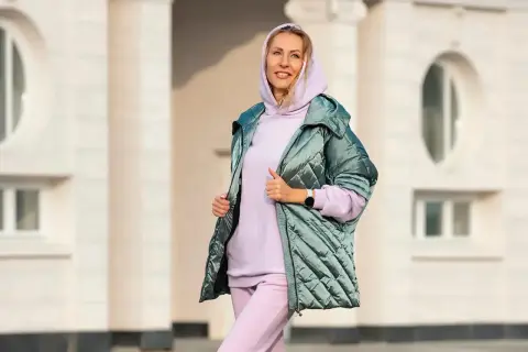 Kobieta w pastelowym dresie i pikowanej kurtce. Idealny zestaw, jak się ubrać na 15 stopni, by czuć się komfortowo i stylowo.