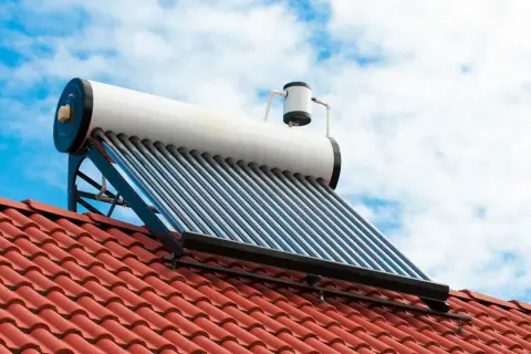 Kolektor słoneczny na dachu do grzania wody. Fotowoltaika w akcji, wykorzystująca energię słońca.