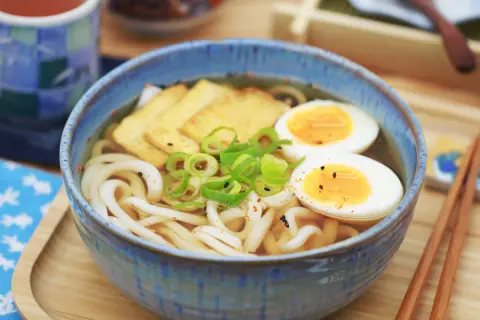 Herzhafte Udon-Nudelsuppe mit pochiertem Ei, Tofu und Frühlingszwiebeln. Ein einfaches Udon-Nudel-Rezept für ein köstliches Essen.