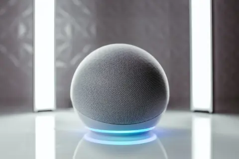 Altavoz esférico gris con anillo de luz azul. Listo para activar Alexa.