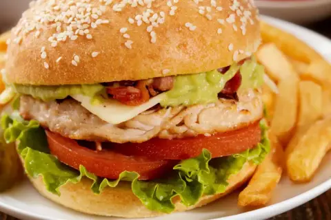 Pyszny fit burger z kurczakiem, awokado i chrupiącymi frytkami. Idealny na zdrowy posiłek.
