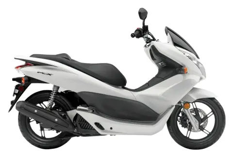 Biały skuter Honda PCX 125, znany z niskiego spalania, na białym tle.