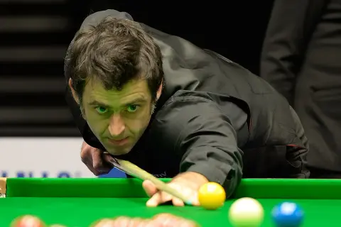 Ronnie O'Sullivan w akcji, skupiony na grze w snookera. Jego sportowa pasja widoczna w każdym ruchu.