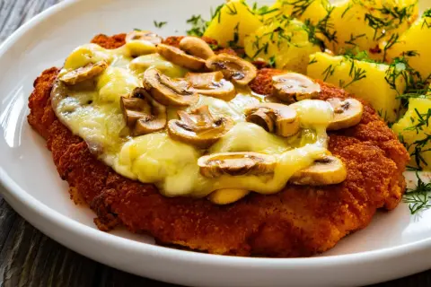 Schab po szwajcarsku z pieczarkami i serem, podany z ziemniakami i koperkiem. Pyszne danie obiadowe.
