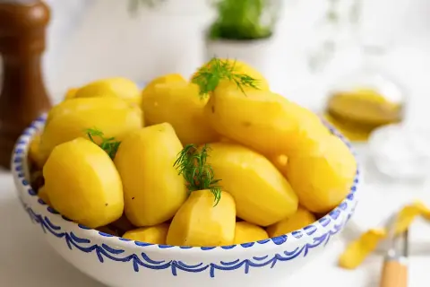 En skål med nykokta, gula potatisar, garnerade med dill. Perfekt för att koka potatis till middagen.
