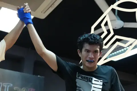 Two fighters shake hands after a bout, one with a blue-wrapped hand. This image offers great sparring tips for improving technique and sportsmanship.