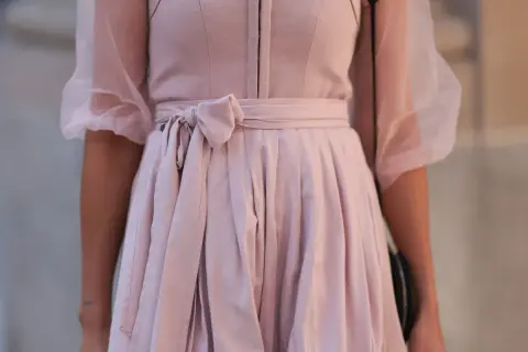 Ein zartrosa Dirndl ohne Schürze mit Puffärmeln aus Tüll. Die Taille ist mit einer Schleife gebunden.