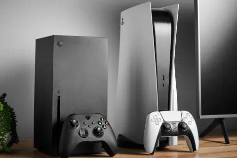Konsola Xbox Series X i PlayStation 5 z kontrolerami na drewnianym stole.