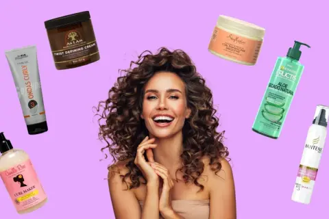 Mujer sonriente con rizos perfectos, rodeada de productos para el cabello: cremas, geles y espumas para definirlos.