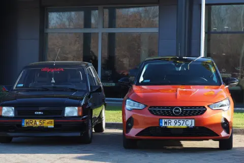 Dwa Ople: klasyczny czarny i nowoczesny pomarańczowy Opel Corsa 2022.