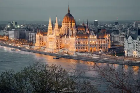 Wspaniały Parlament w Budapeszcie, oświetlony nocą, to obowiązkowy punkt, co zobaczyć w Budapeszcie. Rzeka Dunaj i miejska panorama tworzą magiczny widok.