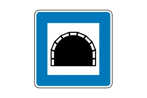 Blaues Verkehrsschild mit weißem Rahmen, das ein schwarzes Tunnelportal zeigt. Dieses tunnel schild warnt vor der Einfahrt in einen Tunnel.