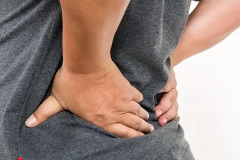 Person med ryggsmärta, en möjlig biverkning av citalopram.