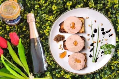 Delicioso foie gras en tostadas, acompañado de una botella de champán y tulipanes. Un festín que evoca de donde viene el foie.
