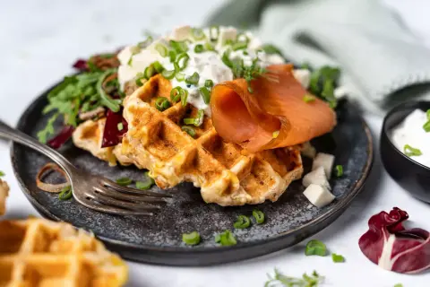 Herzhafte Waffeln mit Räucherlachs, Frischkäse und Schnittlauch. Ein köstliches Gericht, das Lust auf mehr macht.