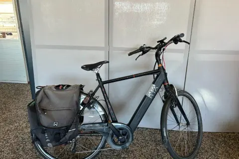 Zwarte Sparta Ion E Speed 2016 e-bike met dubbele fietstassen, klaar voor een rit.