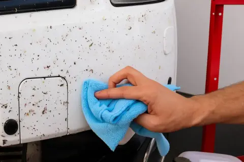 Limpia los restos de insectos del coche con un paño azul. Aprende cómo quitar los mosquitos del coche fácilmente.