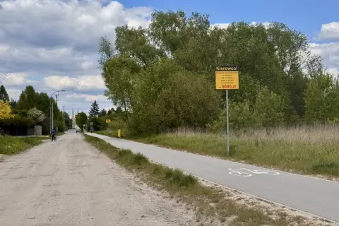 Droga rowerowa z tablicą ostrzegawczą "Kierowco! Za jazdę samochodem po drodze dla rowerów grozi mandat w wysokości do 5000 zł". Czy to rejestracja EPA, jakie miasto?