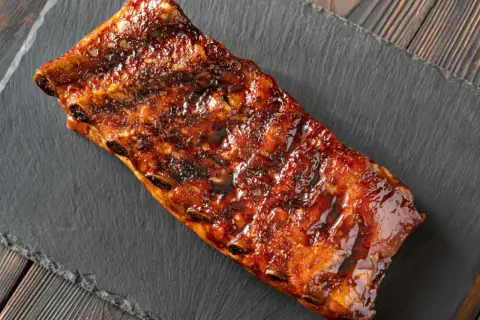 Costillas al horno con miel y mostaza, glaseadas y jugosas, listas para disfrutar.