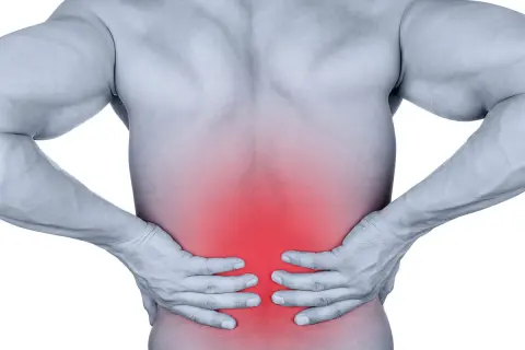 Douleur dans le bas du dos, zone rouge sur le muscle longissimus. Homme tenant ses reins.