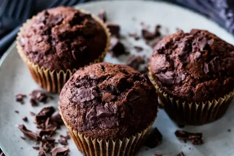 Drei saftige Schoko-Muffins mit Schokostückchen, perfekt für ein schnelles Muffins Rezept.