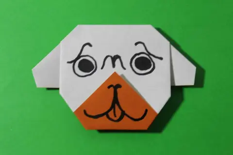 Uroczy origami piesek z pomarańczowym noskiem i czarnymi oczkami. Prosty origami piesek krok po kroku.