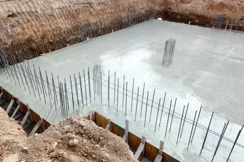 Budowa fundamentów: świeży beton i zbrojenie zapowiadają prawidłową izolację fundamentów.