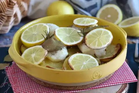 Dos de cabillaud au four, garni de rondelles de citron, de romarin et de feuilles de laurier. Un plat savoureux et parfumé.