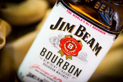 Butelka Jim Beam White Label, z charakterystycznym logo i napisem "Bourbon". Idealna na wieczór z przyjaciółmi.