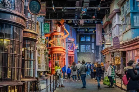 En magisk gata i Harry Potter England. Besökare njuter av Diagongränden med dess unika butiker.