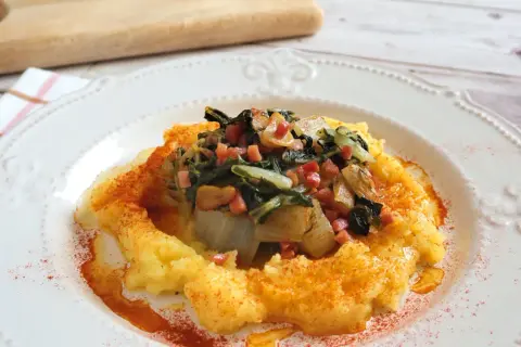 Puré de patatas con un sofrito de acelgas y trocitos de jamón. Una deliciosa receta con acelgas, espolvoreada con pimentón.