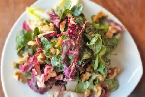 Frischer Feldsalat mit Radicchio und Walnüssen, verfeinert mit einem cremigen Kartoffeldressing.