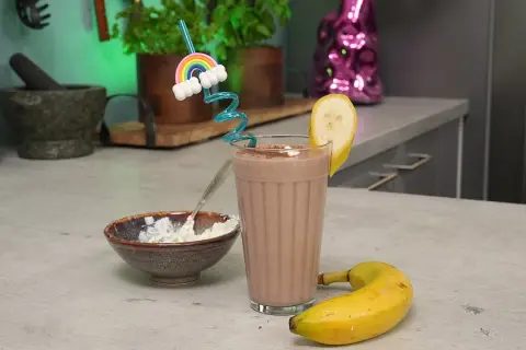 Leckeres protein shake rezept mit Banane und einer Prise Kakao. Dazu eine Schüssel mit Quark.