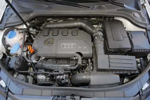 Widok komory silnika z widocznym silnikiem 2.0 TFSI Audi, zbiornikiem płynu chłodniczego i filtrem powietrza.