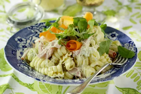 En härlig god pasta sallad med skinka, morötter och örter, toppad med riven ost. Perfekt för en lätt lunch eller middag.