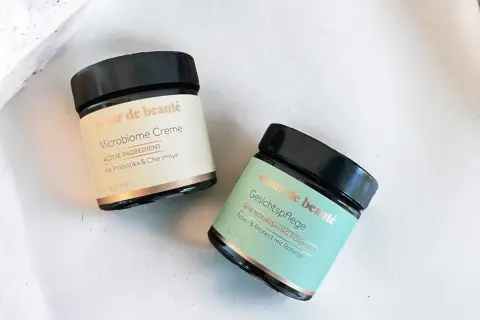 Zwei Tiegel "coeur de beauté" Microbiome Creme und Gesichtspflege, die auf probiotische Hautpflege setzen.