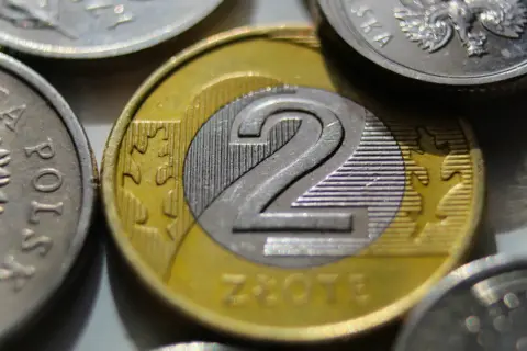 Dwie monety dwuzłotowe, symbolizujące zarobki na umowie zlecenie, gdzie najniższa krajowa jest punktem wyjścia.