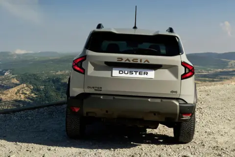 Tył nowego Dacia Duster 2025 z napędem 4x4 na górskiej drodze.