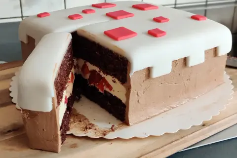 En chokladtårta med vit marsipan och röda dekorationer, inspirerad av Minecraft. Perfekt för ett Minecraft tårta recept!