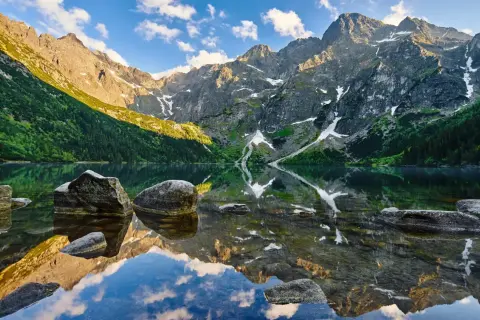 Tatry latem: Morskie Oko odbija skaliste szczyty i zielone zbocza. Idealne miejsce na wakacje, by odkryć bukowina tatrzańska atrakcje.