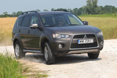 Brązowy Mitsubishi Outlander 2008 na drodze polnej, w tle pole zboża.