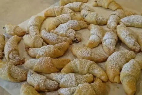 Mnóstwo pysznych, domowych rogalików z powidłami, posypanych cukrem pudrem. Idealne na deser lub do kawy.