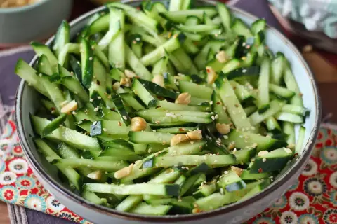 Una fresca insalata di cetrioli tagliati a julienne, condita con semi di sesamo, arachidi e peperoncino.