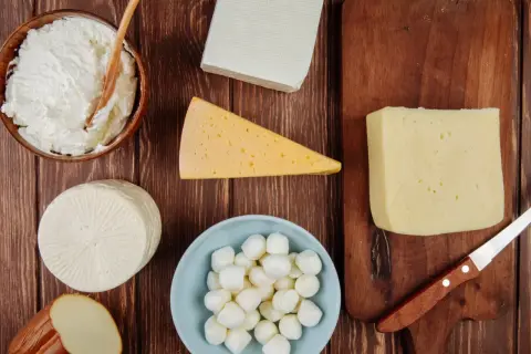 Różne rodzaje serów: twaróg, mozzarella, ser żółty, ser wędzony i ser biały.